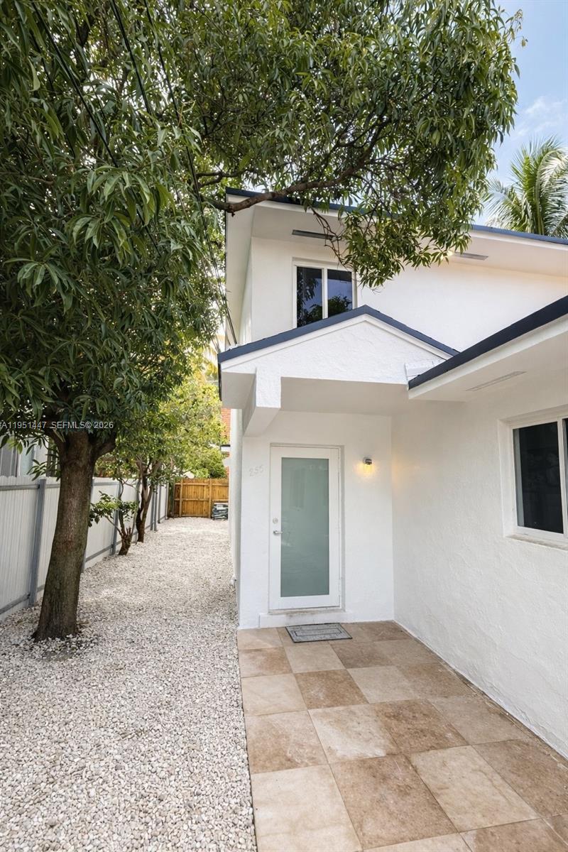 236 Northeast 55th Terrace, Unit 236 Miami, FL 33137 - Photo 9 of 10 a view of a white house with a large tree and a yard