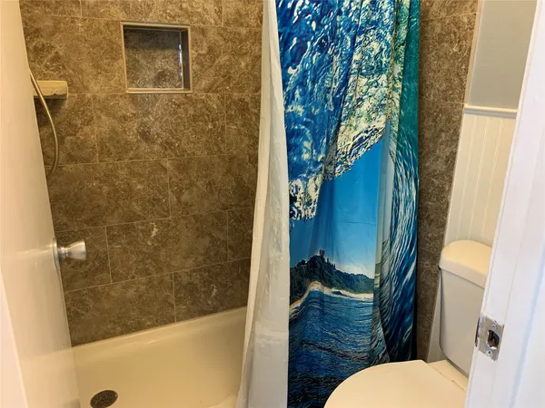 a bathroom with a toilet and a shower