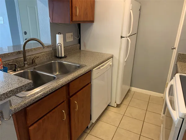 a kitchen with a sink a refrigerator and cabinets