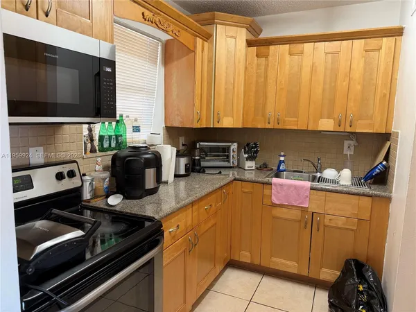 a kitchen with a stove a sink and a microwave