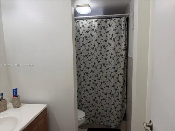 a bedroom with a bed and view of kitchen