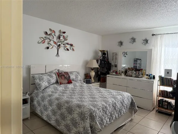 a bedroom with a bed and a view of kitchen