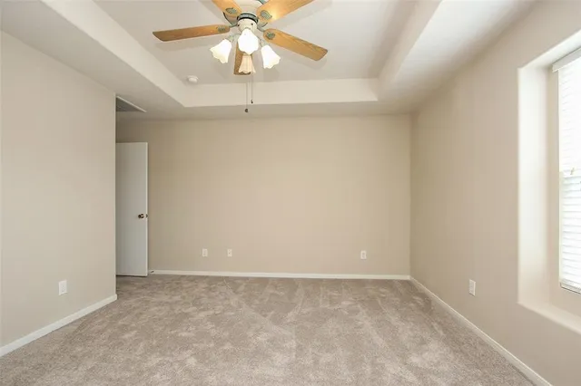 an empty room with windows and fan