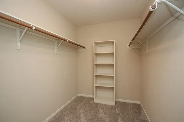 a view of walk in closet with empty racks