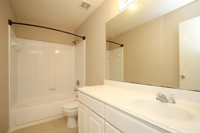 a bathroom with a bathtub shower sink vanity and toilet