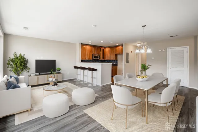 a living room with furniture kitchen view and a flat screen tv