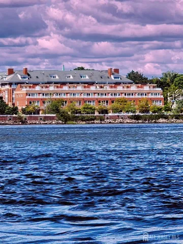 a front view of a building with lot of street and trees