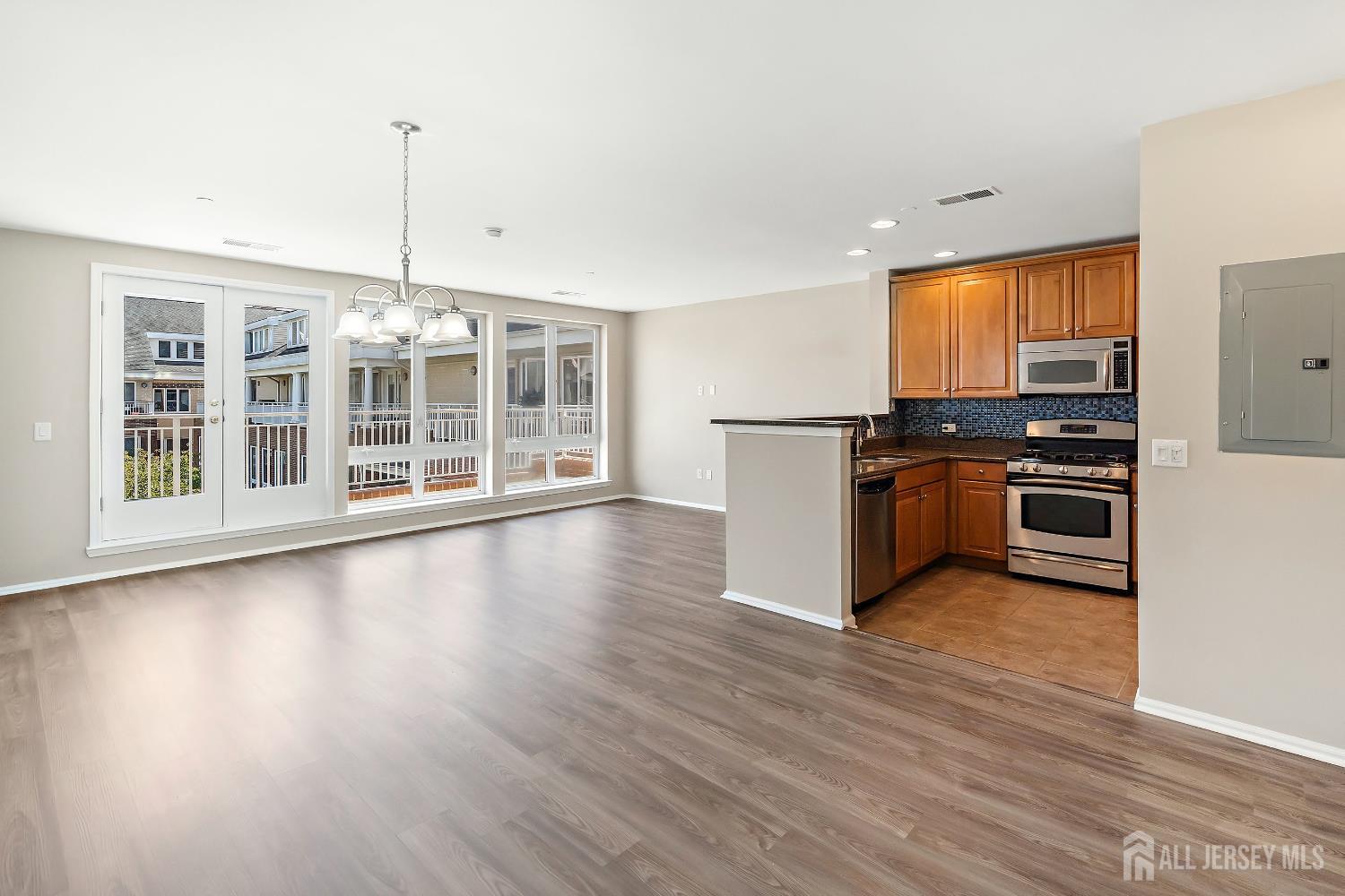 368 Rector Street, Unit 521 Perth Amboy, NJ 08861 - Photo 5 of 41 a kitchen with stainless steel appliances granite countertop a stove top oven a sink with wooden floors