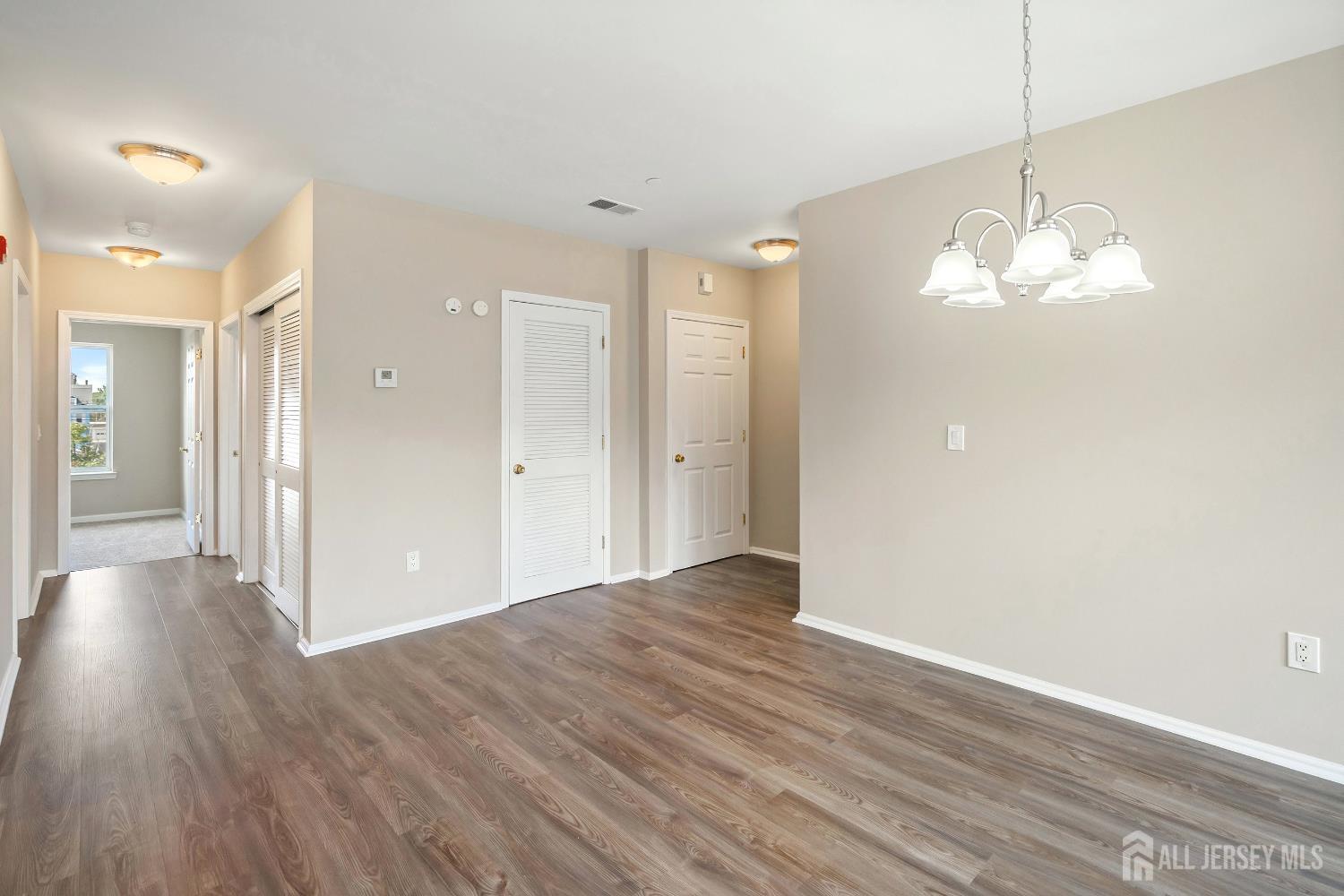 368 Rector Street, Unit 521 Perth Amboy, NJ 08861 - Photo 9 of 41 a view of a hallway with wooden floor and a chandelier