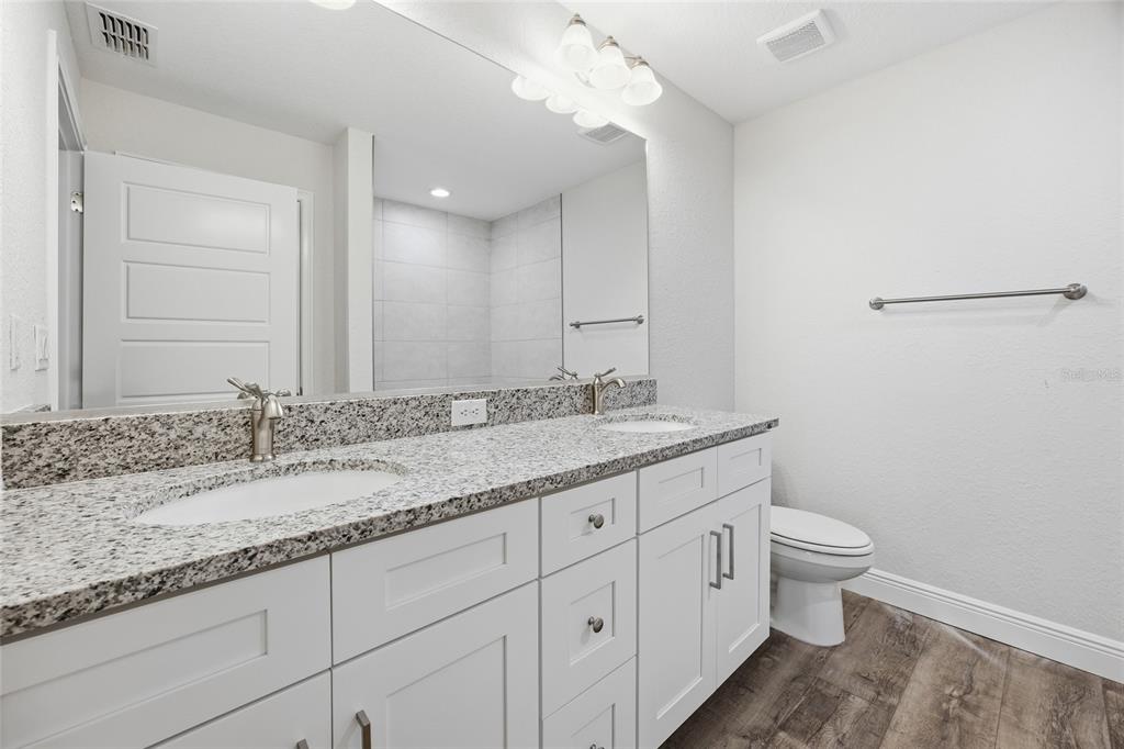 6762 Cherry Road Ocala, FL 34472 - Photo 11 of 29 a bathroom with a granite countertop sink a toilet and a mirror