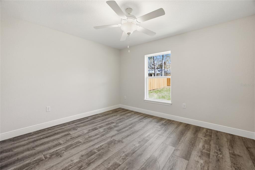 6762 Cherry Road Ocala, FL 34472 - Photo 13 of 29 an empty room with wooden floor and windows
