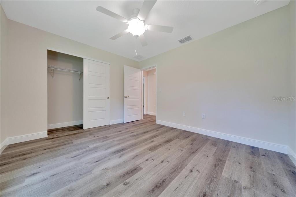 6762 Cherry Road Ocala, FL 34472 - Photo 19 of 29 an empty room with wooden floor and a ceiling fan