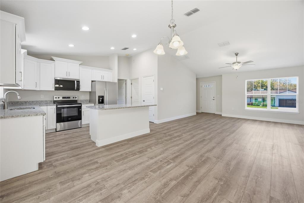 6762 Cherry Road Ocala, FL 34472 - Photo 6 of 29 a view of kitchen with granite countertop stainless steel appliances cabinets a wooden floor and a window