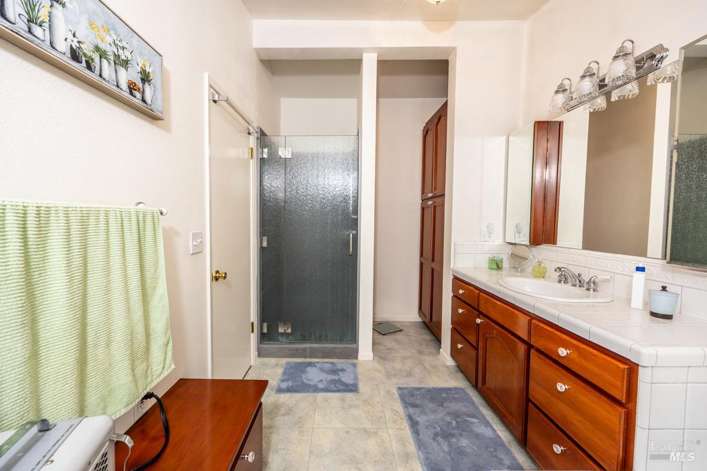 6707 Badger Creek Road Santa Rosa, CA 95409 - Photo 24 of 53 a bathroom with a double vanity sink mirror and shower