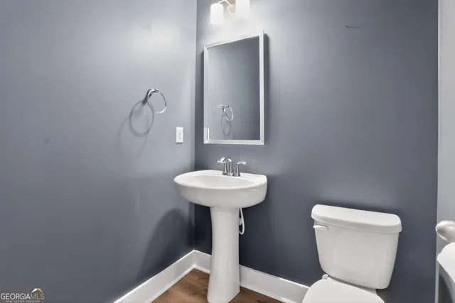 a bathroom with a toilet sink and mirror