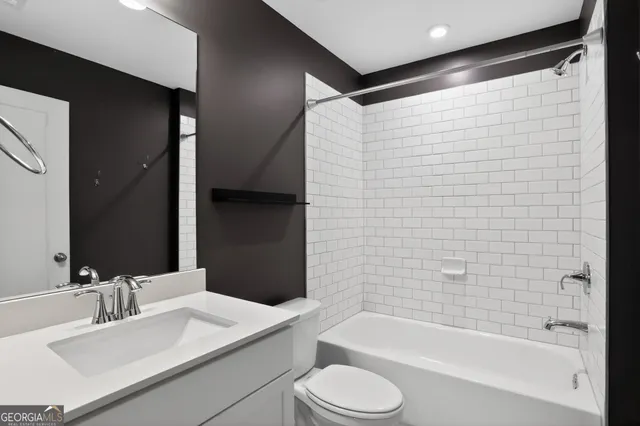 a bathroom with a bathtub shower sink vanity and toilet