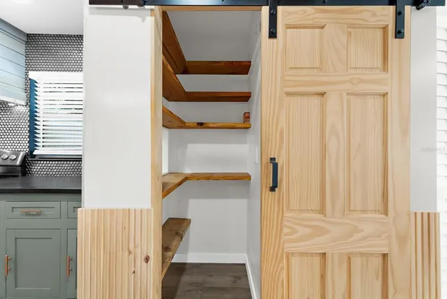 a view of empty room with wooden floor and ceiling fan