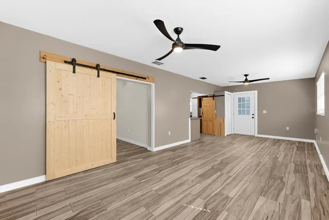 a view of a room has wooden floor and a window
