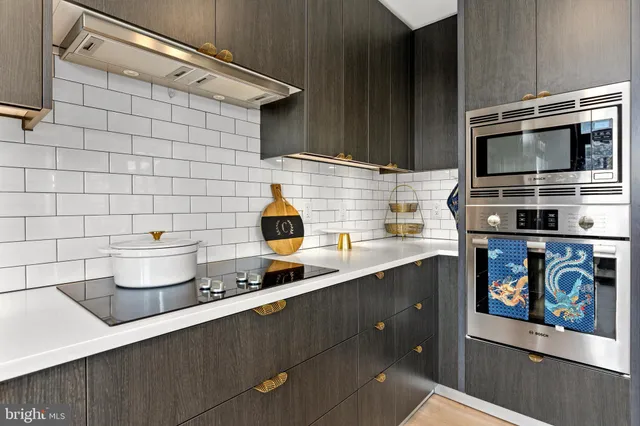 a kitchen with stainless steel appliances a sink a stove and cabinets
