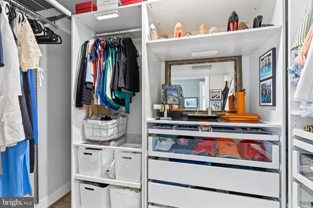 a view of walk in closet with clothes and shoes