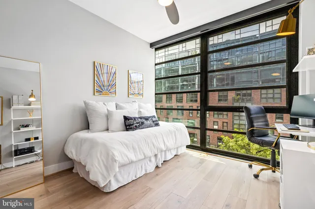 a bedroom with a bed furniture and a large window