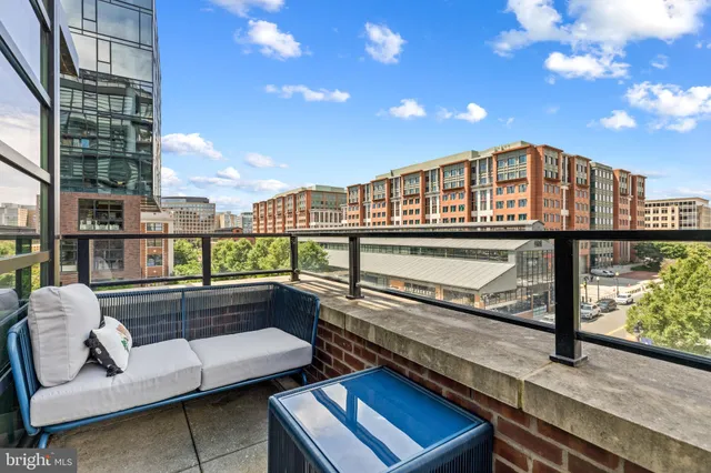 a view of a balcony with couches and wooden floor