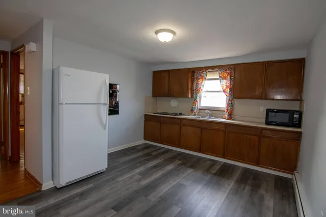 a kitchen with granite countertop wooden floors and white stainless steel appliances