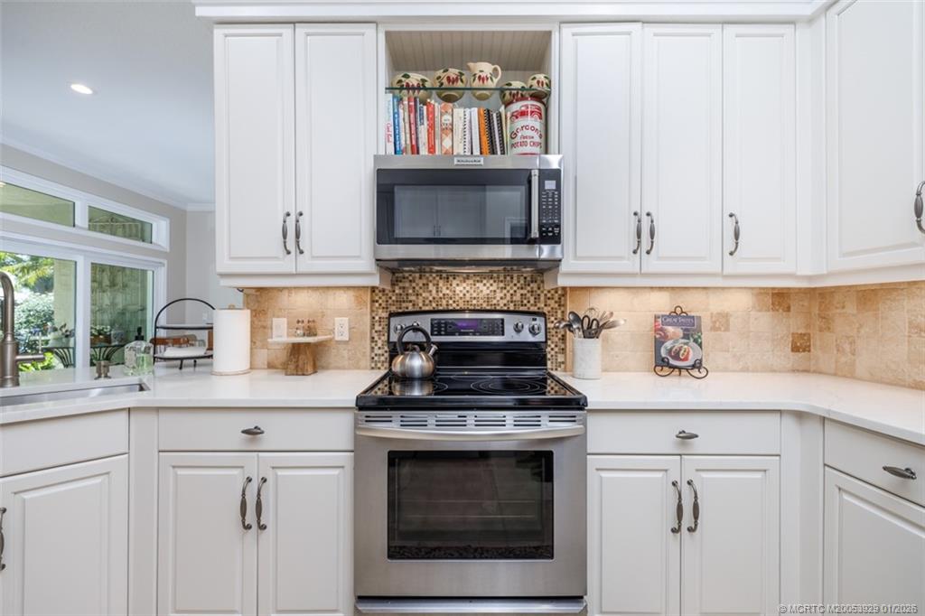 1976 Southwest Oak Ridge Road Palm City, FL 34990 - Photo 17 of 65 a kitchen with white cabinets and appliances