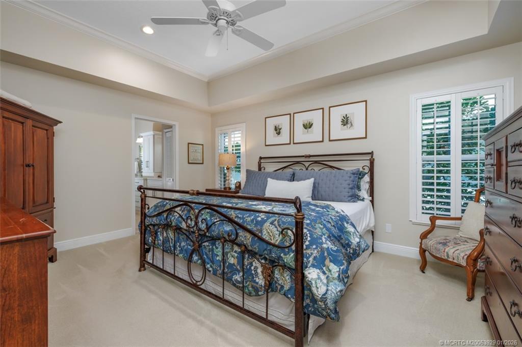 1976 Southwest Oak Ridge Road Palm City, FL 34990 - Photo 19 of 65 a bedroom with a bed and a chandelier