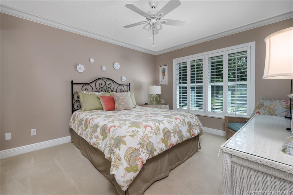 1976 Southwest Oak Ridge Road Palm City, FL 34990 - Photo 24 of 65 a bedroom with a large bed and a large window