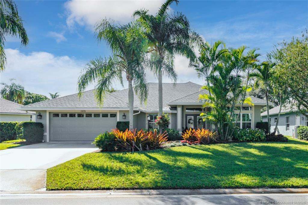 1976 Southwest Oak Ridge Road Palm City, FL 34990 - Photo 3 of 65 a front view of house with yard and outdoor seating