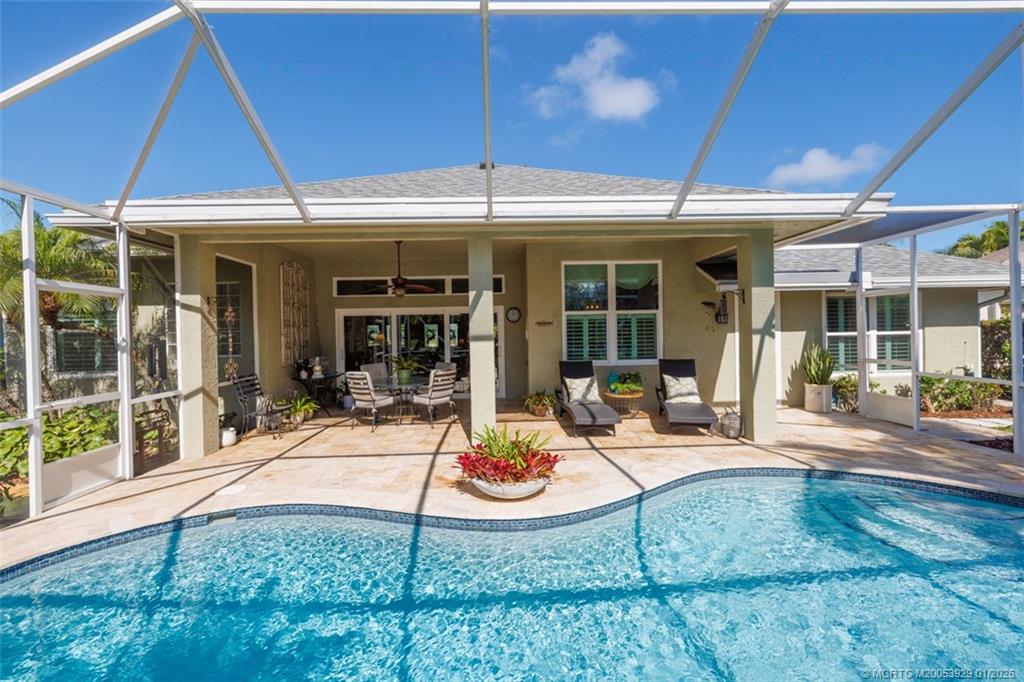 1976 Southwest Oak Ridge Road Palm City, FL 34990 - Photo 33 of 65 a view of a patio with table and chairs under an umbrella