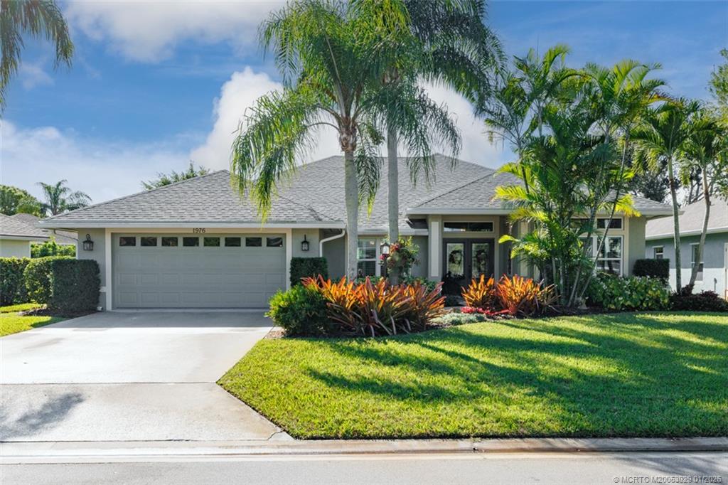 1976 Southwest Oak Ridge Road Palm City, FL 34990 - Photo 4 of 65 a front view of a house with a yard and potted plants