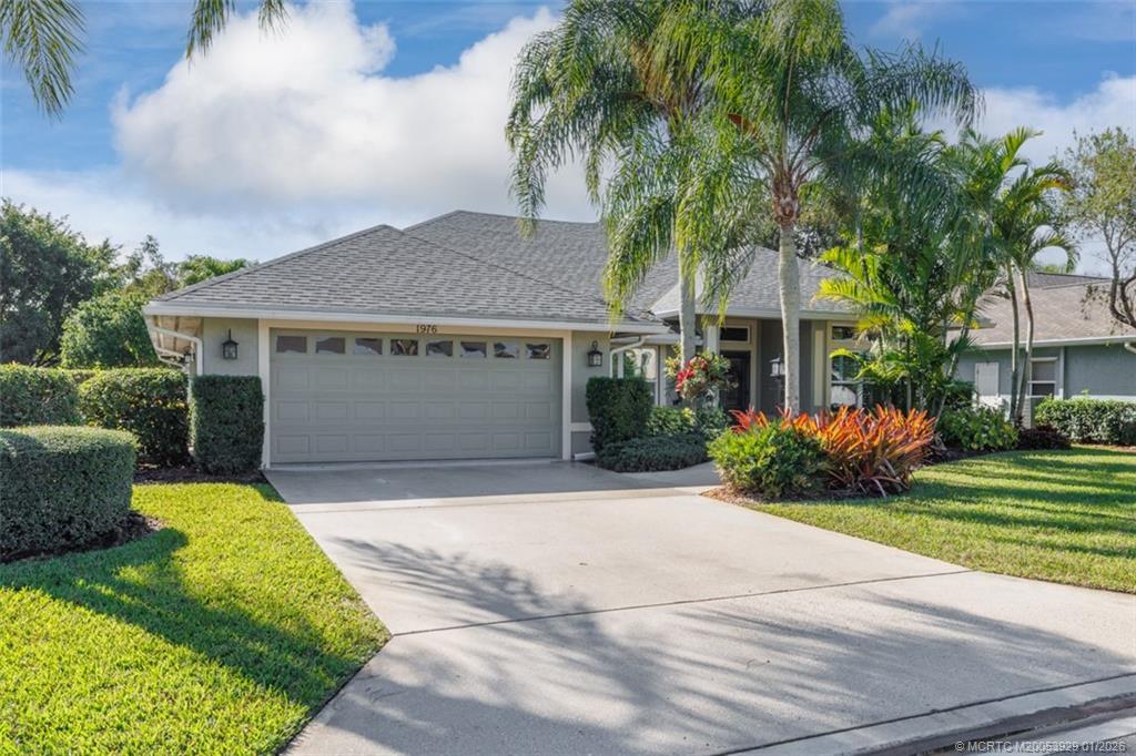 1976 Southwest Oak Ridge Road Palm City, FL 34990 - Photo 5 of 65 a front view of a house with a garden and trees