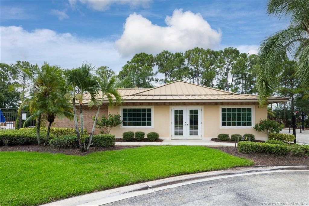 1976 Southwest Oak Ridge Road Palm City, FL 34990 - Photo 52 of 65 a front view of a house with a garden and plants