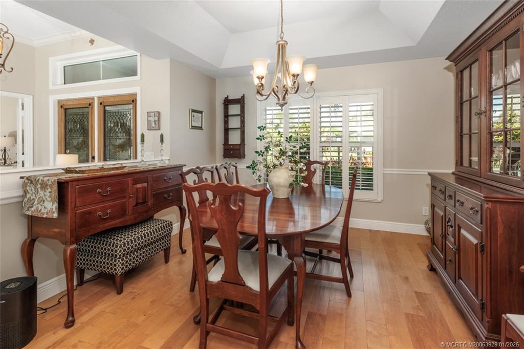 1976 Southwest Oak Ridge Road Palm City, FL 34990 - Photo 10 of 65 a dining room with furniture a chandelier and wooden floor
