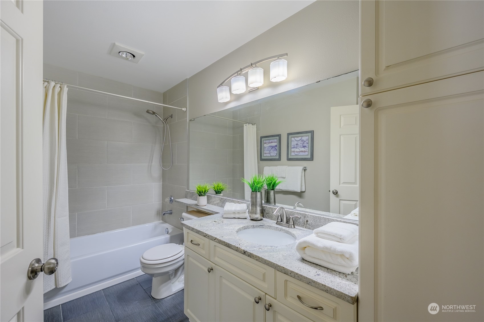 18501 Southeast Newport Way, Unit H236 Issaquah, WA 98027 - Photo 17 of 25 a bathroom with a granite countertop sink a toilet a mirror and shower