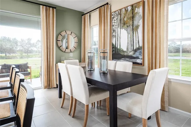 a view of a dining room with furniture large windows and wooden floor