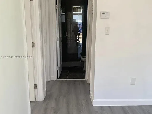 a view of a hallway with wooden floor