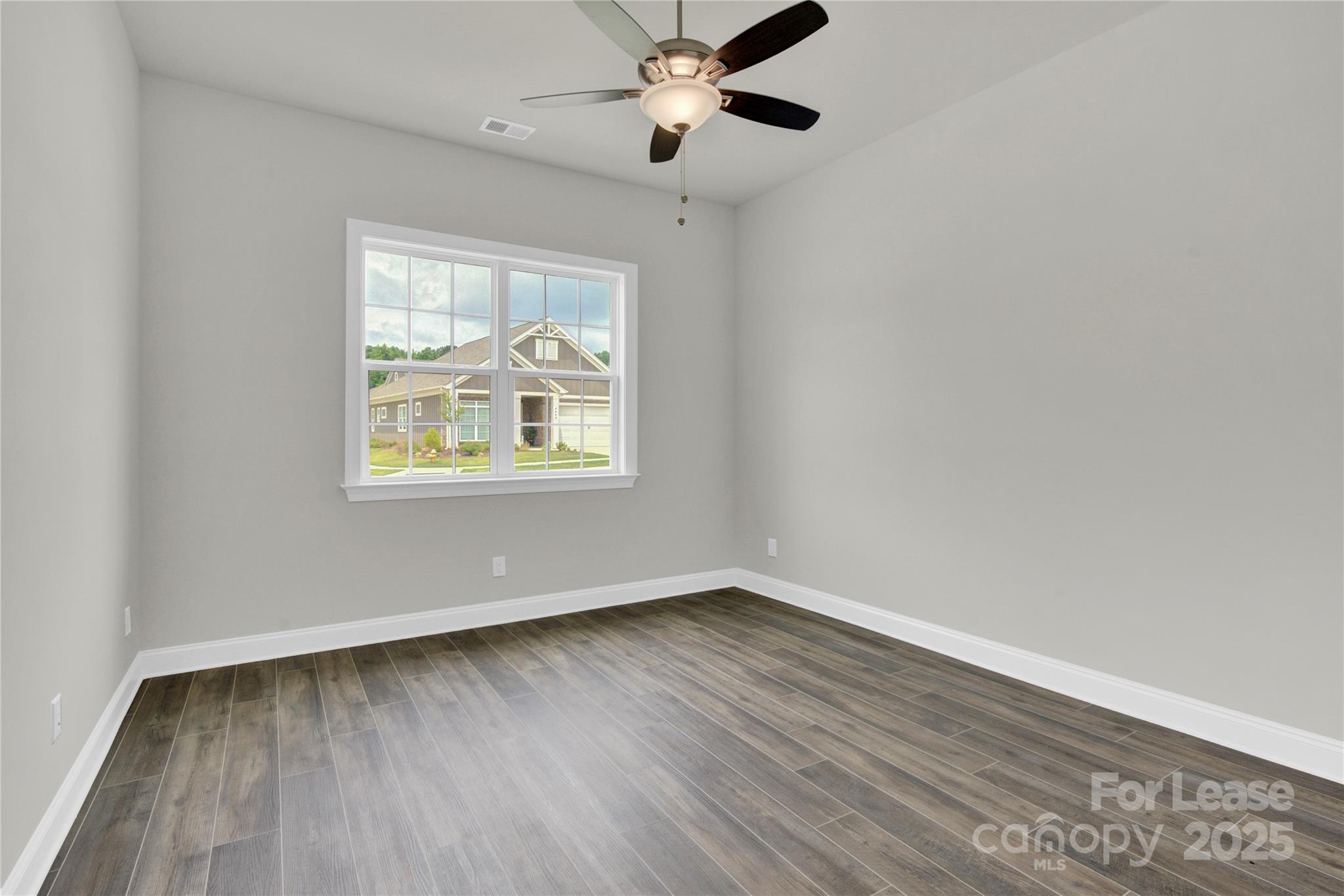 4715 Anise Circle, Unit 40 Sherrills Ford, NC 28673 - Photo 14 of 20 an empty room with wooden floor chandelier fan and windows
