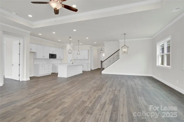 a view of kitchen with a sink wooden cabinets and window