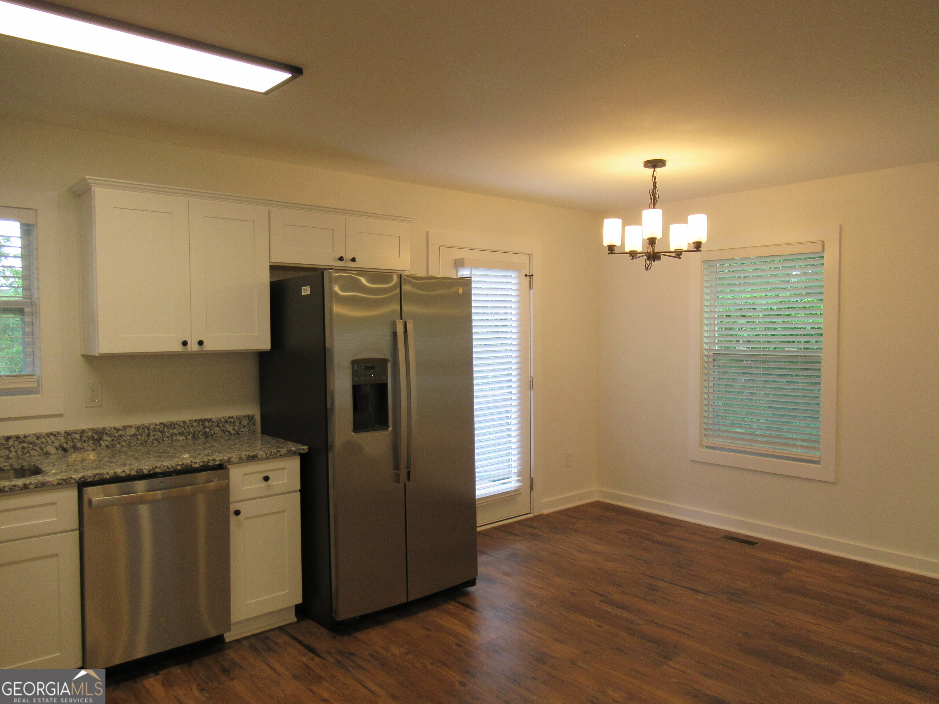 765 Old Kerns Road Dawsonville, GA 30534 - Photo 6 of 36 a kitchen with granite countertop a refrigerator a sink and wooden floor