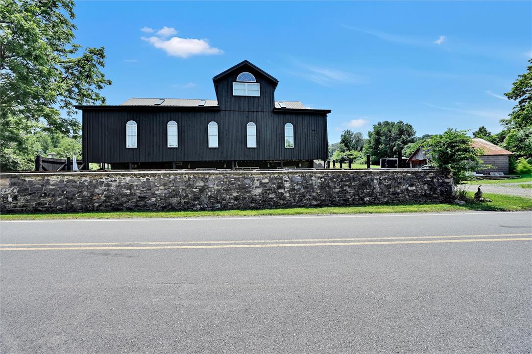 101 Conrad Road Fleetwood, PA 19522 - Photo 39 of 42 A striking black structure, with classic arched windows, stands proudly behind a sturdy stone wall.