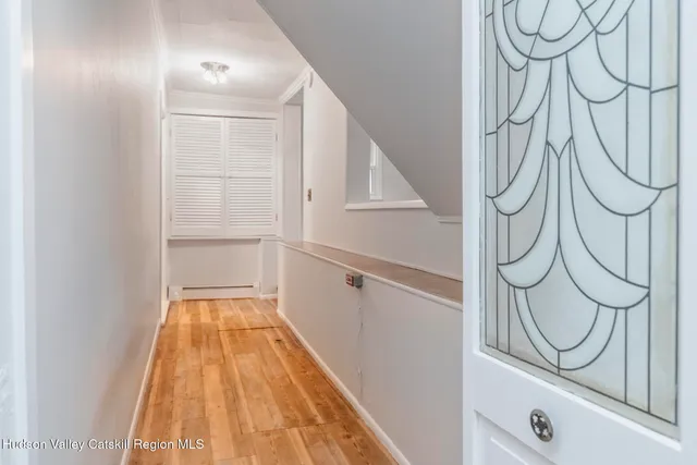 a view of an empty room with window and wooden floor