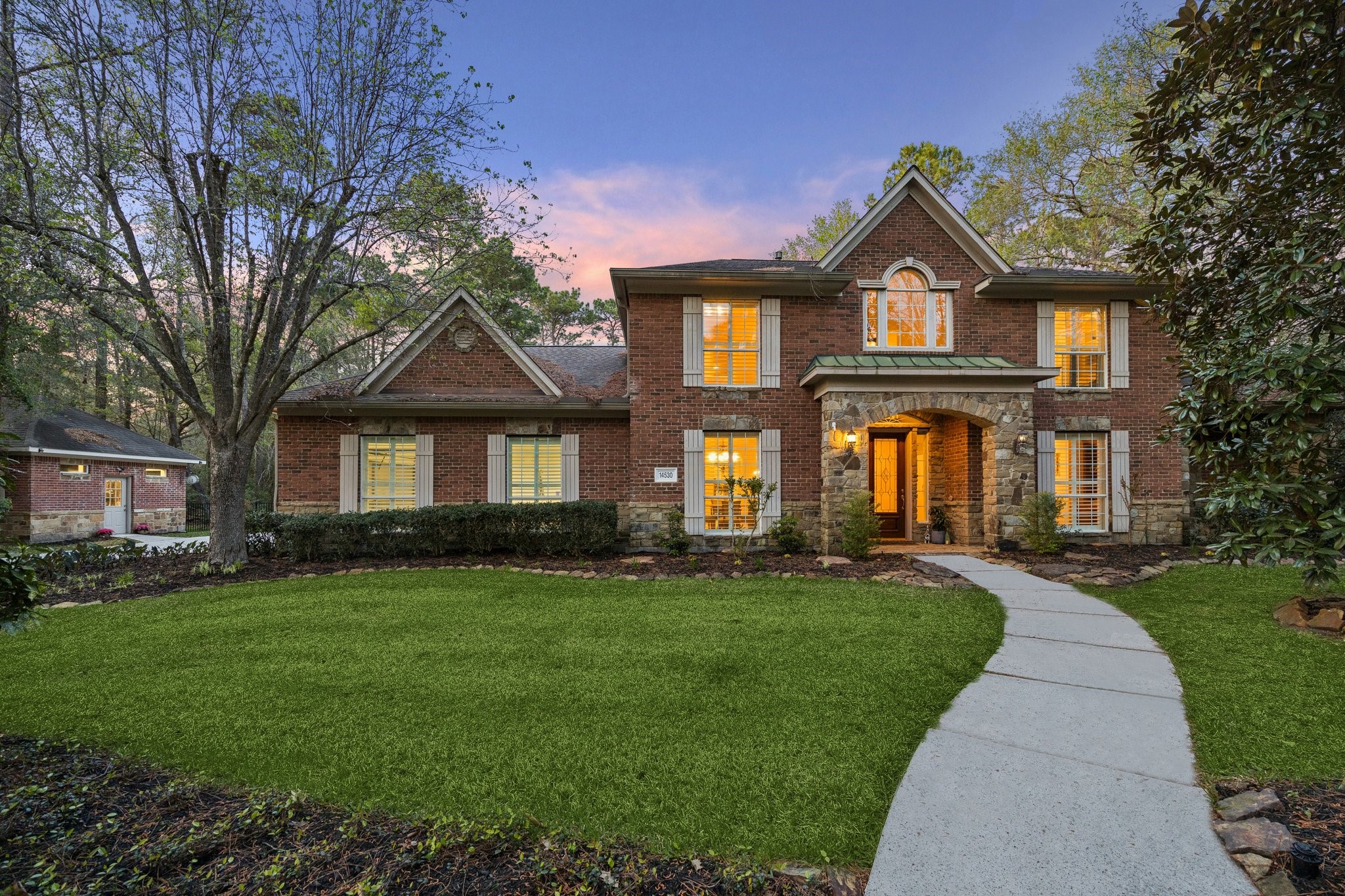 14530 Millhouse Road Pinehurst, TX 77362 - Photo 1 of 43 Welcome home to this stately brick home on a wooded homesite in the gated community of Old Mill Lake, framed by mature trees and established landscaping, with a curved walkway guiding you to the covered front entry.