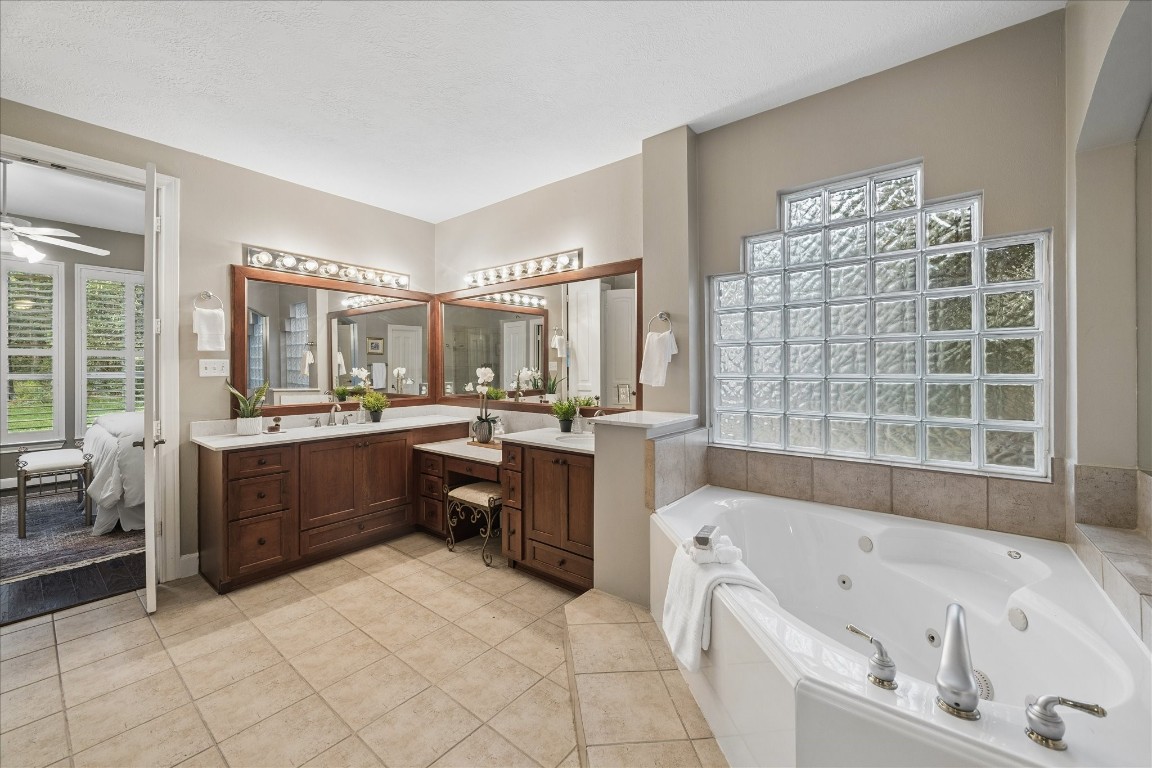 14530 Millhouse Road Pinehurst, TX 77362 - Photo 21 of 46 Additional view of the primary bathroom highlighting the soaking tub with glass block window detail and dual vanity with storage.