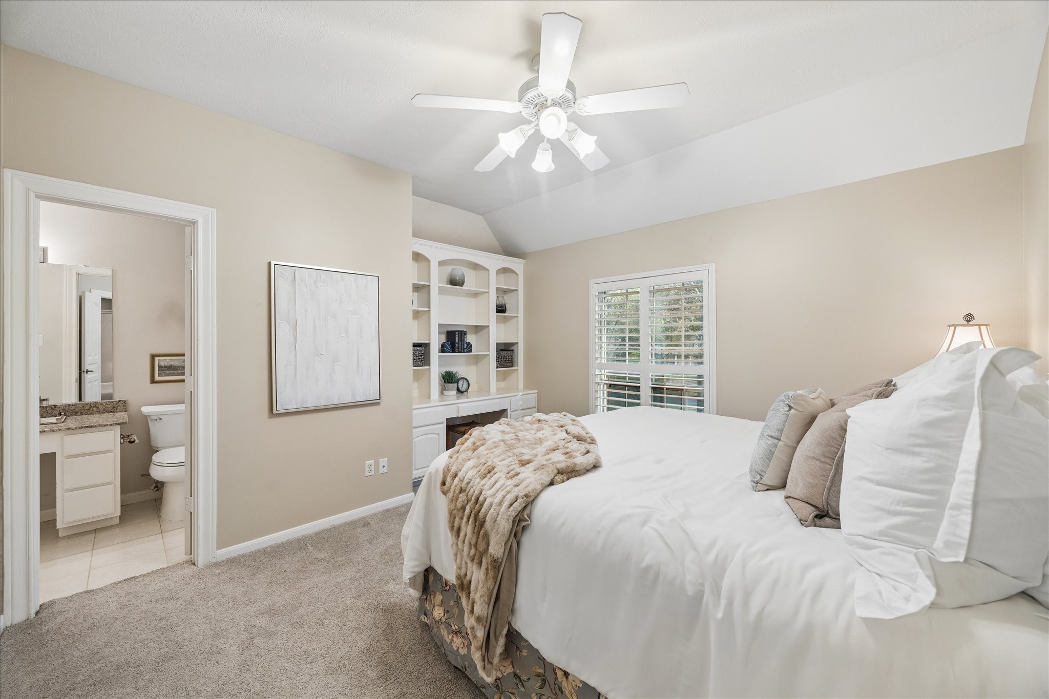 14530 Millhouse Road Pinehurst, TX 77362 - Photo 23 of 43 Upstairs bedroom with carpeting, built-in shelving with dedicated desk area and convenient access to an ensuite bathroom.