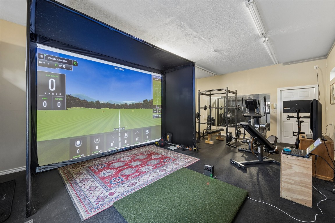 14530 Millhouse Road Pinehurst, TX 77362 - Photo 31 of 46 Versatile workshop currently set up with a golf simulator and fitness studio, providing a climate-controlled environment for year-round recreation and training.