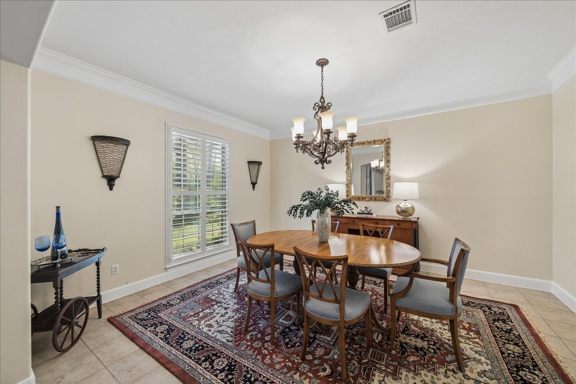 14530 Millhouse Road Pinehurst, TX 77362 - Photo 7 of 46 Formal dining room with chandelier, crown molding, and window with plantation shutters, providing natural light and space for hosting gatherings and special occasions.