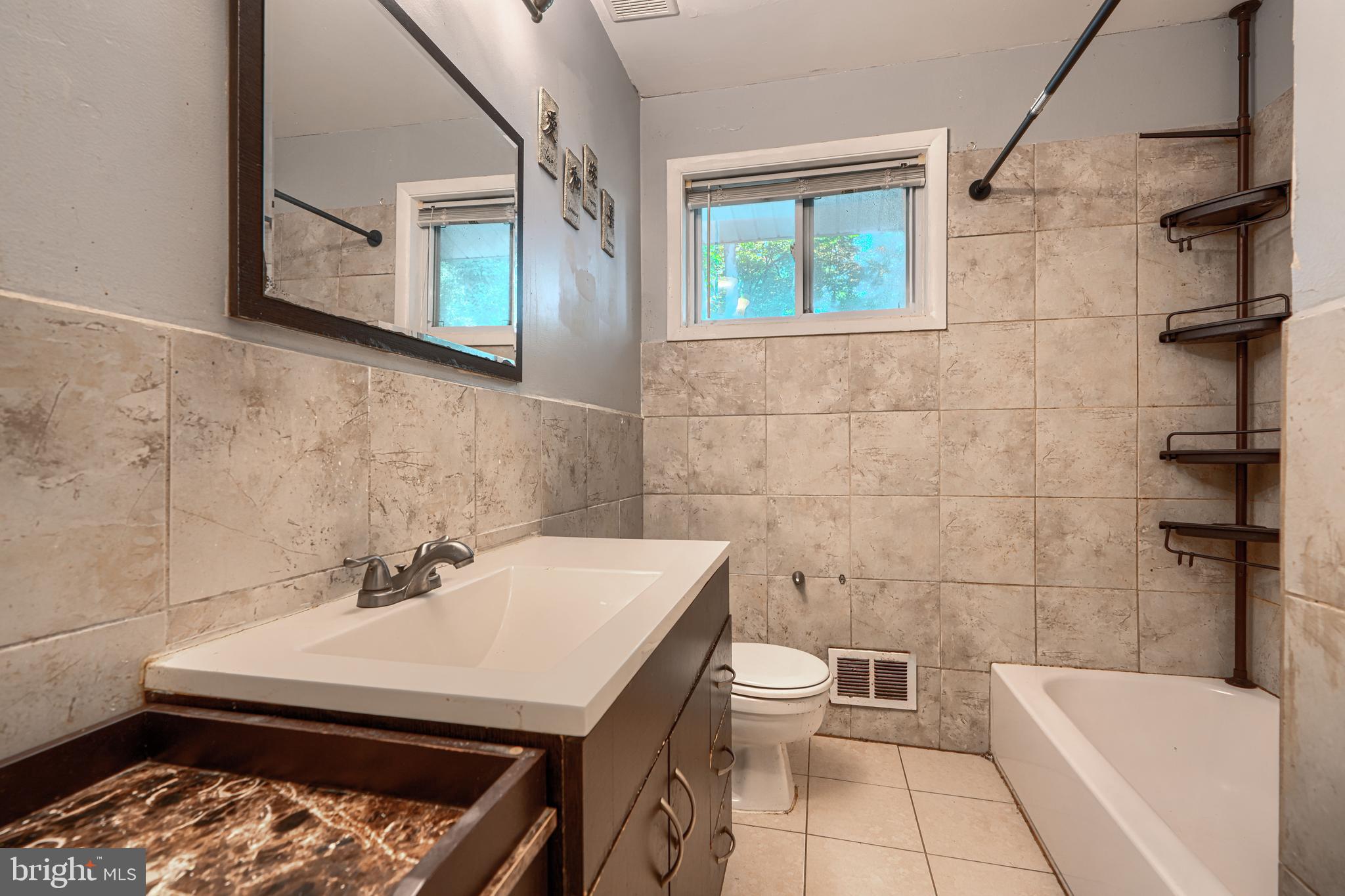 9706 Liberty Road Randallstown, MD 21133 - Photo 30 of 43 a bathroom with a sink a toilet and shower